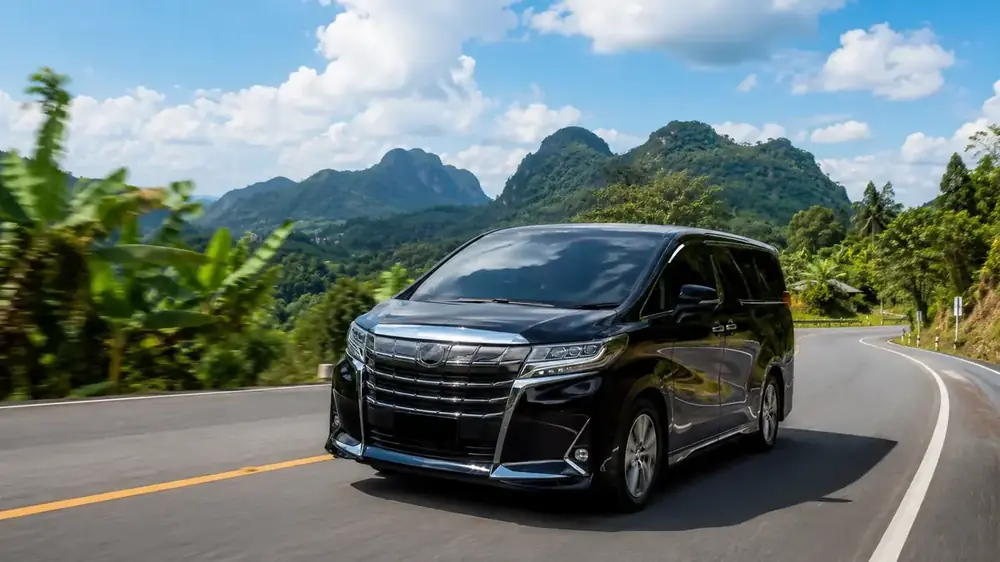 Black premium van on a mountain road in Thailand